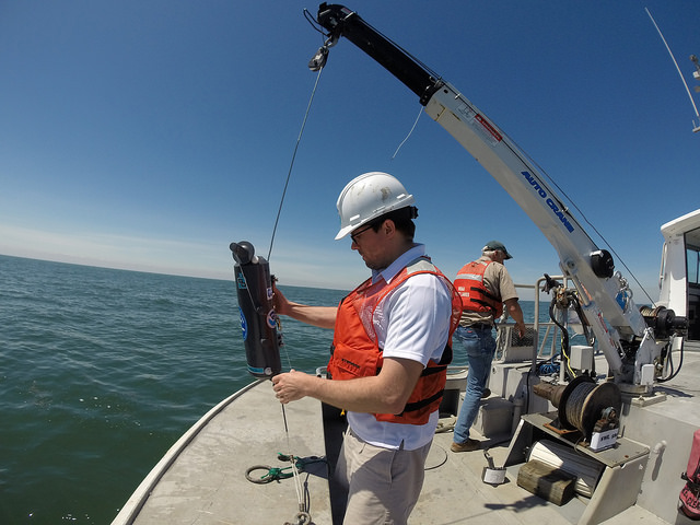 NOAA GLERL scientist T. Davis collects water samples from Lake Erie on Ocean Sampling Day, June 21, 2014. Credit: NOAA.